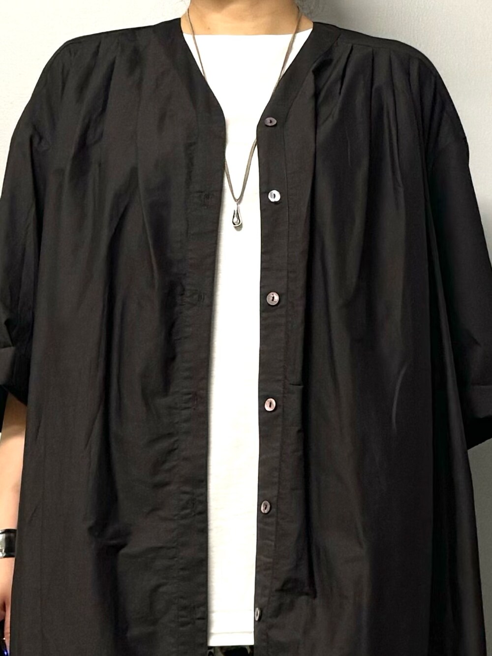 ブラック系のワンピース、ブラック系のサンダル、ホワイト系のTシャツ/カットソーを着用したレディースの夏コーディネートの7枚目の写真