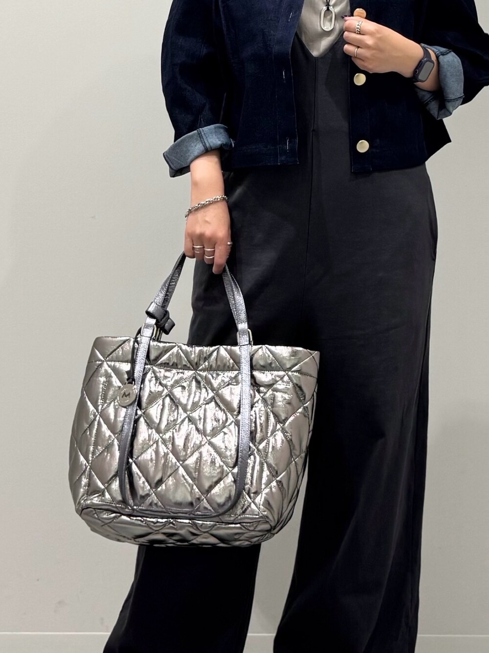 シルバー系のトートバッグ、グレー系のサロペット/オーバーオール、グレー系のTシャツ/カットソーを着用したレディースの秋コーディネートの7枚目の写真