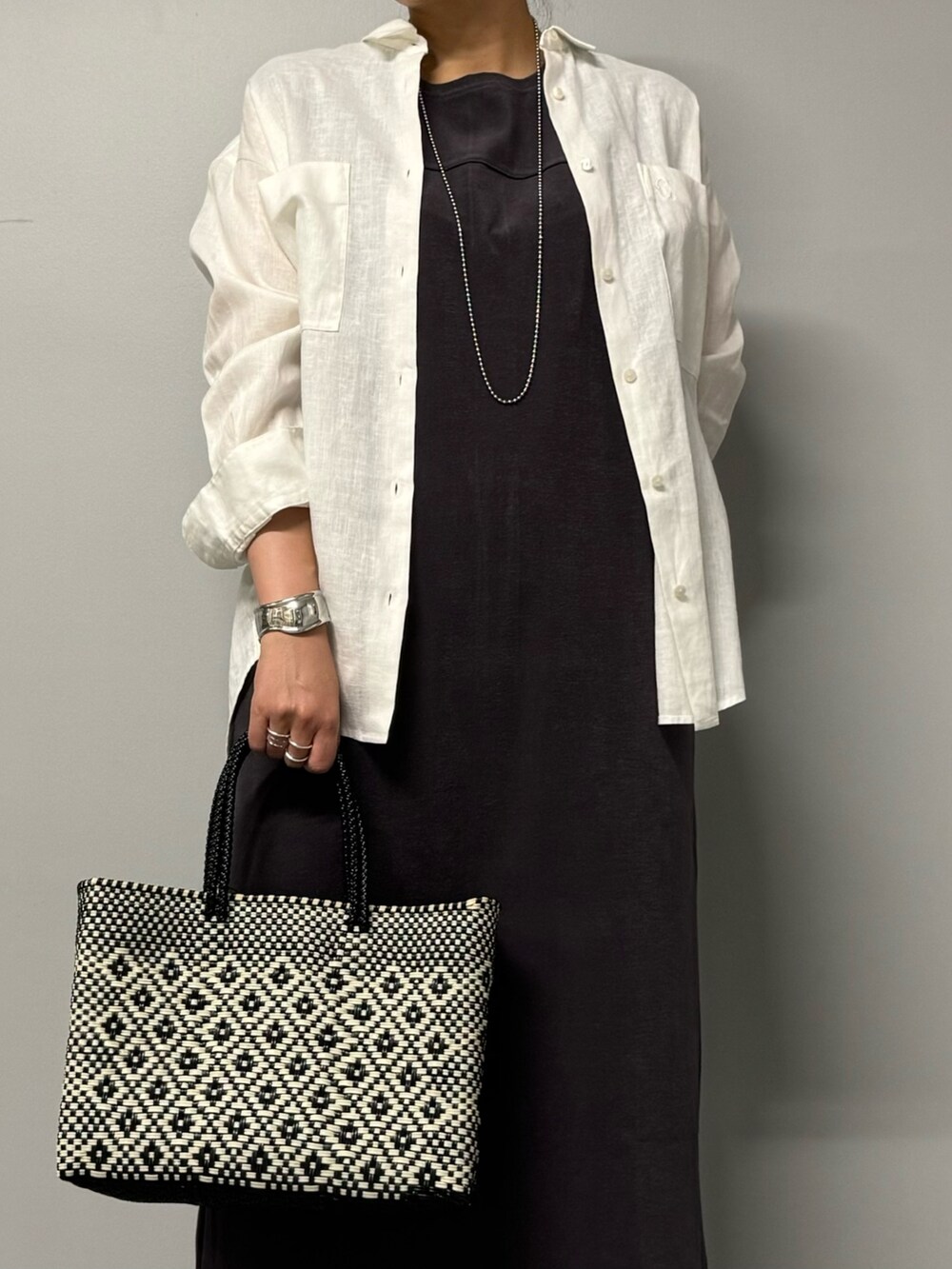 グレー系のワンピース、ホワイト系のシャツ/ブラウス、ブラック系のサンダルを着用したレディースの夏コーディネートの5枚目の写真