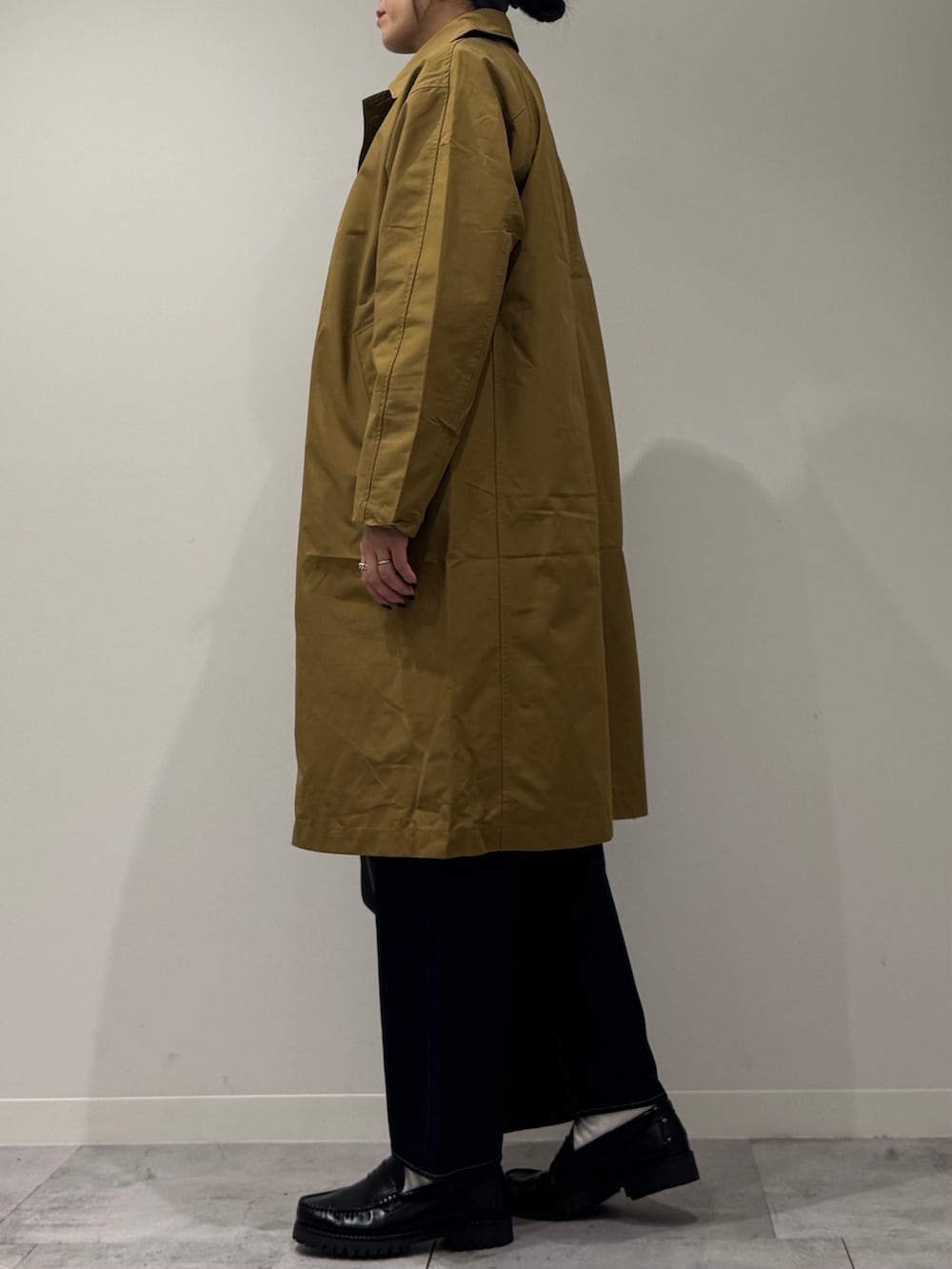 ブラック系のボストンバッグ、ベージュ系のダウンジャケット/コート、ブルー系のデニムパンツを着用したレディースの冬コーディネートの6枚目の写真