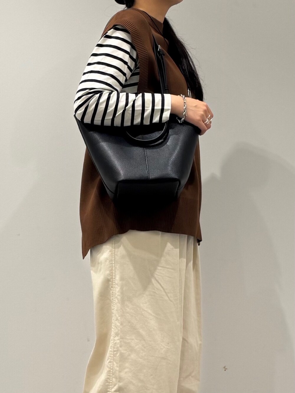 ブラック系のトートバッグ、ブラック系のTシャツ/カットソー、ホワイト系のその他パンツを着用したレディースの冬コーディネートの6枚目の写真