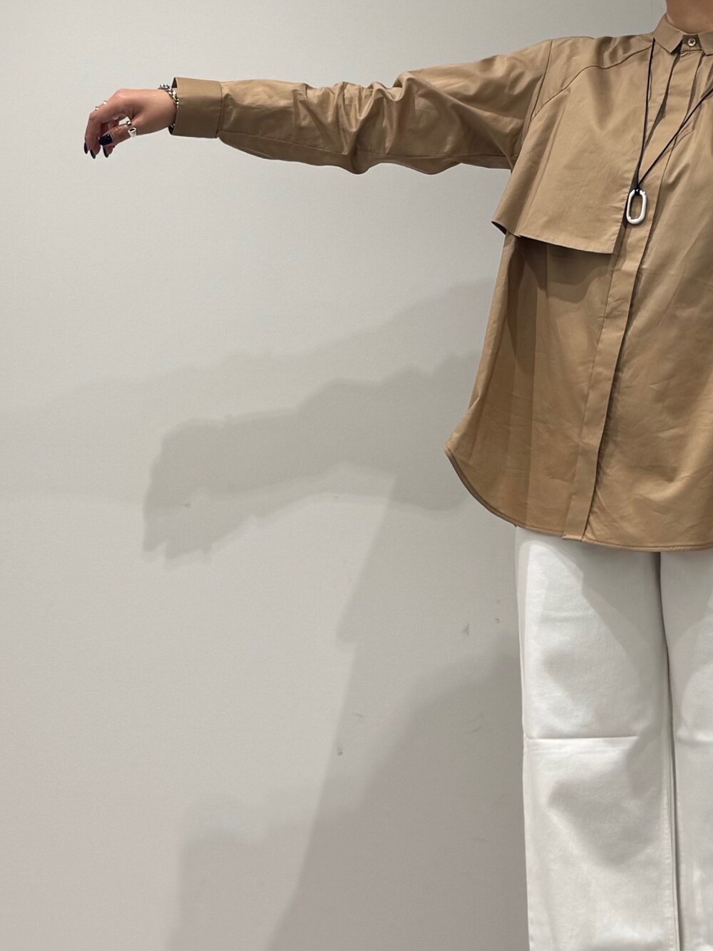 ベージュ系のシャツ/ブラウス、ホワイト系のデニムパンツ、ブラック系のボストンバッグを着用したレディースの秋コーディネートの7枚目の写真