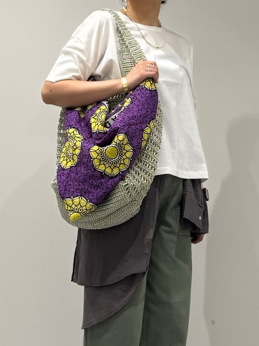 ゴールド系のかごバッグ、グレー系のシャツ/ブラウス、グリーン系のその他パンツを着用したレディースの夏コーディネートの8枚目の写真