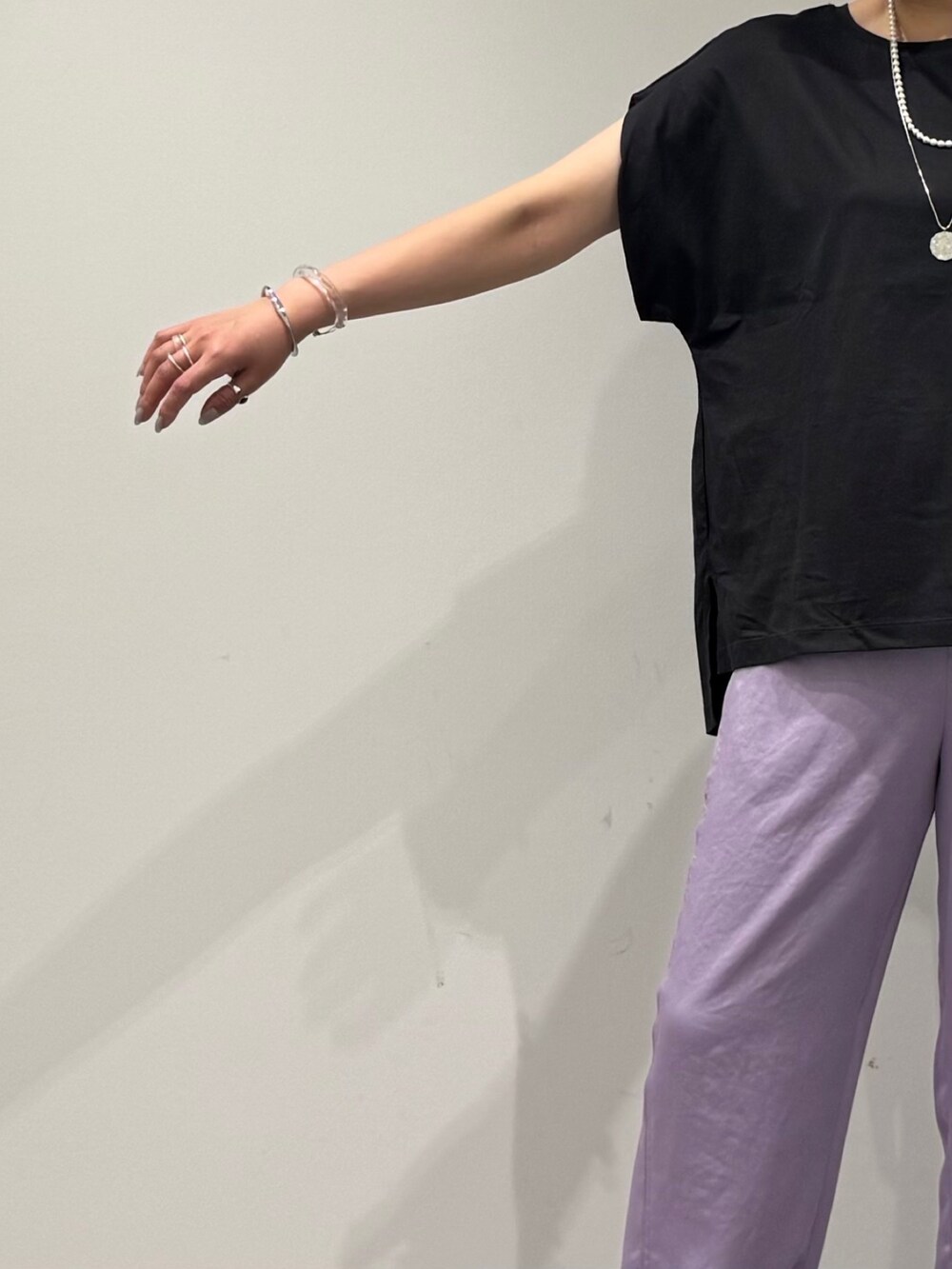 グレー系のTシャツ/カットソー、シルバー系のかごバッグ、ブラック系のサンダルを着用したレディースの夏コーディネートの7枚目の写真