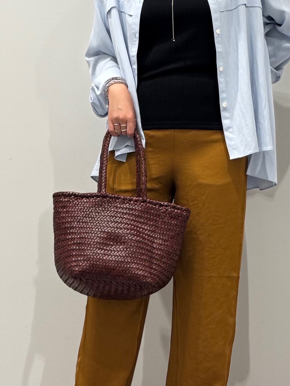 ブラウン系のトートバッグ、ブラウン系のその他パンツ、ブラック系のサンダルを着用したレディースの秋コーディネートの8枚目の写真