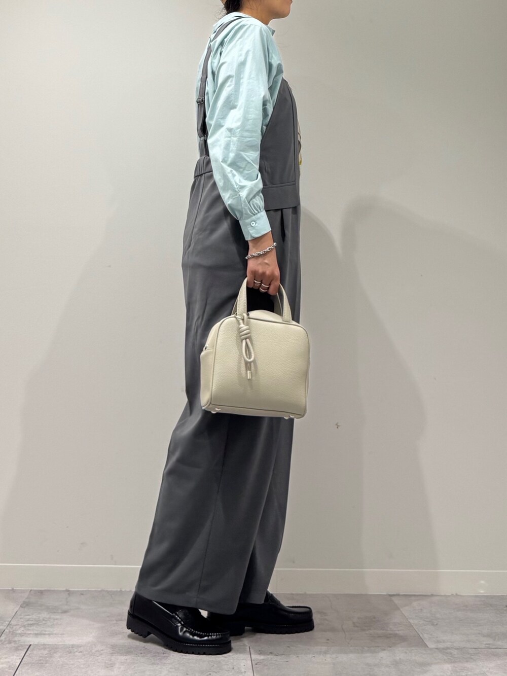 ブラック系のローファー、グレー系のサロペット/オーバーオール、グレー系のボストンバッグを着用したレディースの秋コーディネートの2枚目の写真