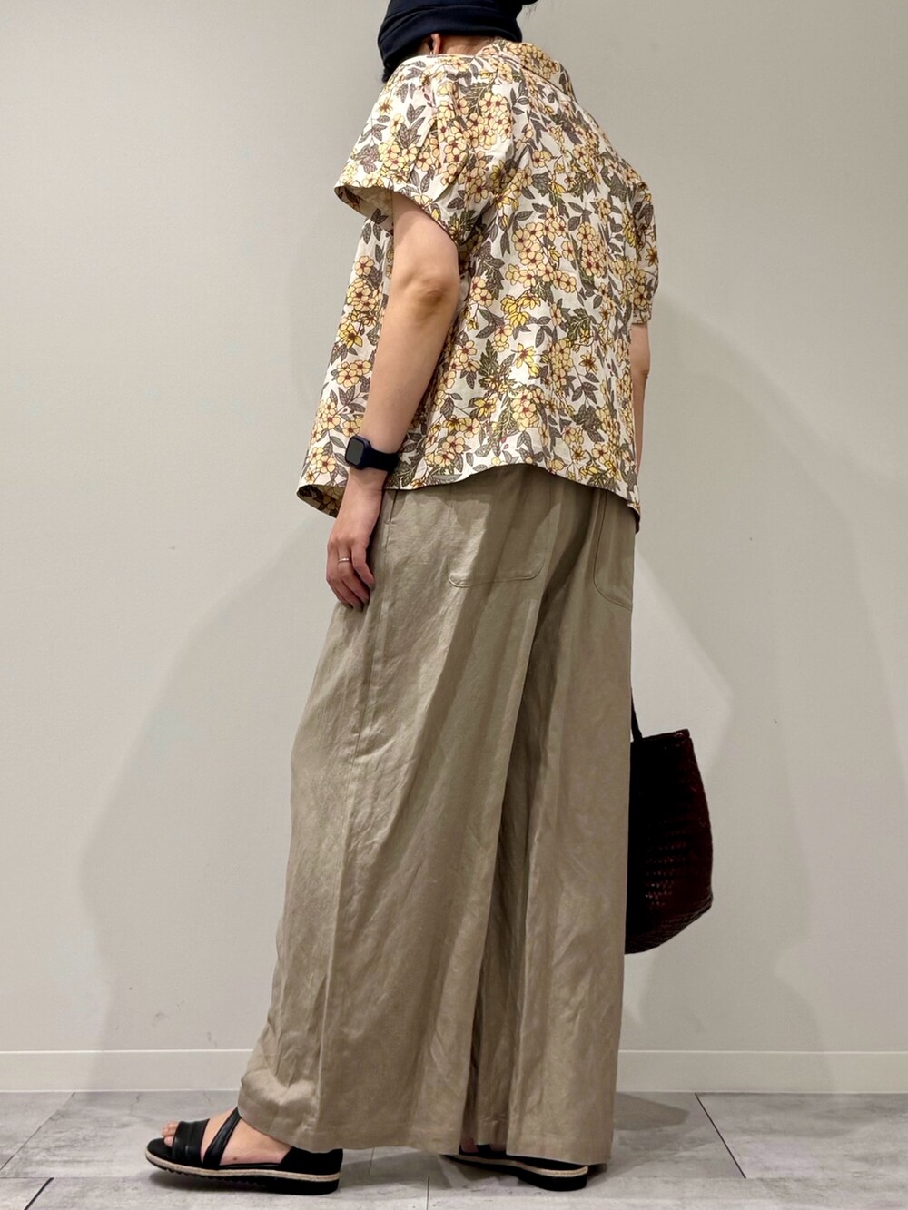 ブラウン系のトートバッグ、ベージュ系のサロペット/オーバーオール、ブラック系のサンダルを着用したレディースの春コーディネートの5枚目の写真