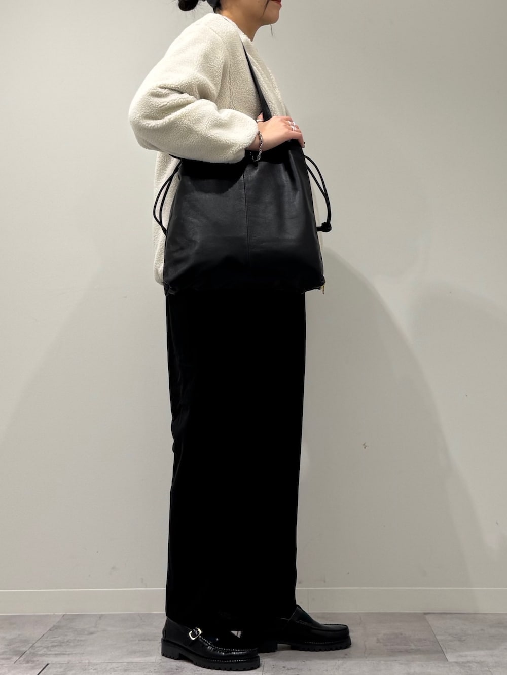 ブラック系のトートバッグ、ブラック系のサロペット/オーバーオール、ブラック系のローファーを着用したレディースの冬コーディネートの2枚目の写真