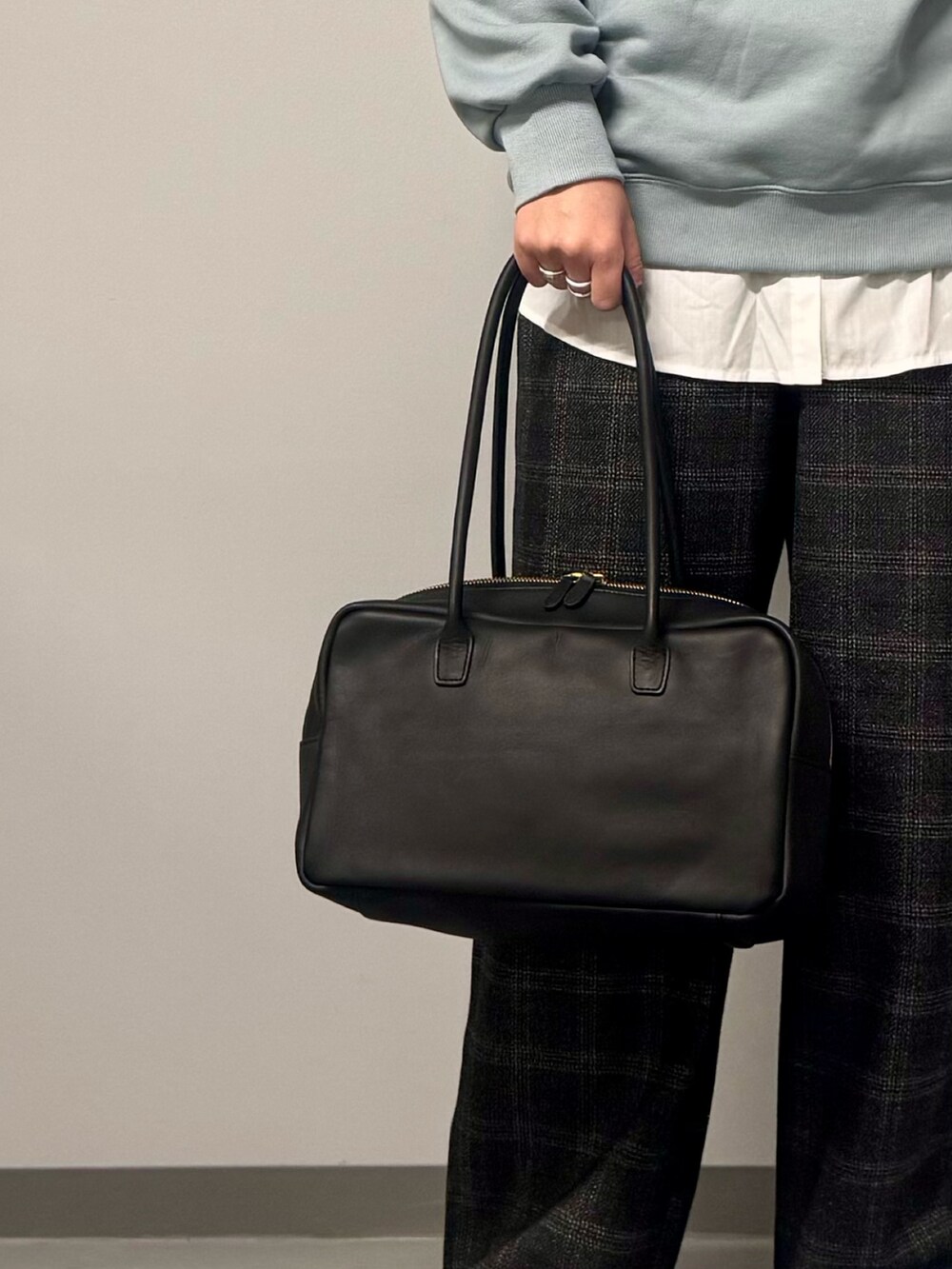 ブルー系のスウェット、ブラウン系のその他パンツ、ブラック系のボストンバッグを着用したレディースの冬コーディネートの9枚目の写真