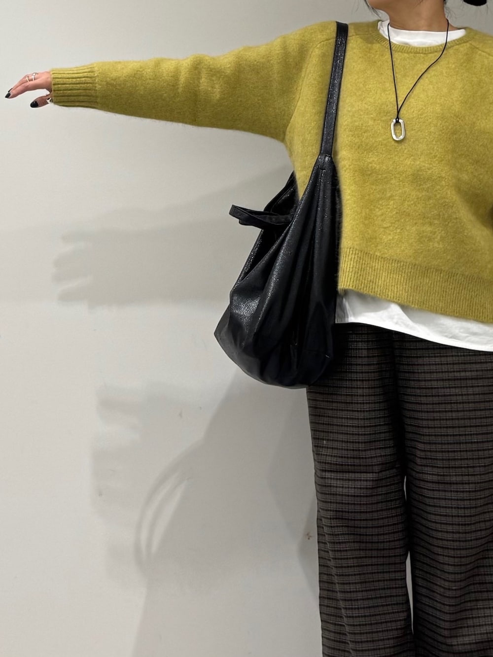 ブラック系のトートバッグ、ブラウン系のその他パンツ、ブラック系のローファーを着用したレディースの冬コーディネートの6枚目の写真