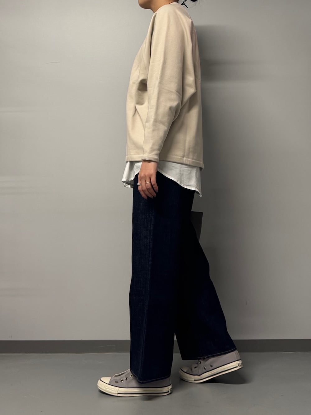 ベージュ系のスウェット、ブルー系のデニムパンツ、グレー系のトートバッグを着用したレディースの冬コーディネートの3枚目の写真
