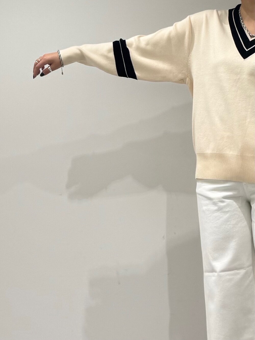 パープル系のトートバッグ、ホワイト系のデニムパンツ、ブラック系のローファーを着用したレディースの冬コーディネートの6枚目の写真