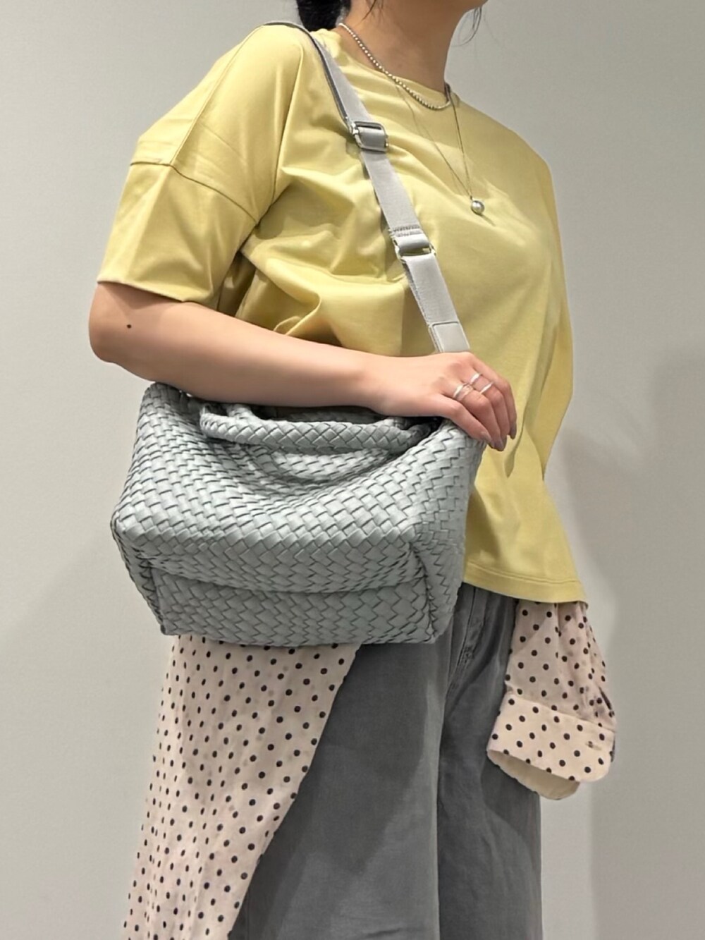 グレー系のトートバッグ、グレー系のデニムパンツ、ホワイト系のシャツ/ブラウスを着用したレディースの春コーディネートの9枚目の写真