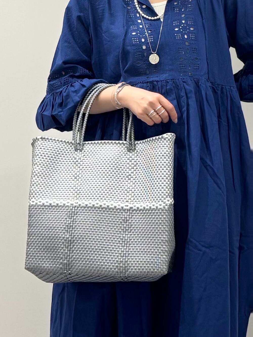 シルバー系のかごバッグ、ブラック系のサンダル、ベージュ系のその他パンツを着用したレディースの春コーディネートの10枚目の写真