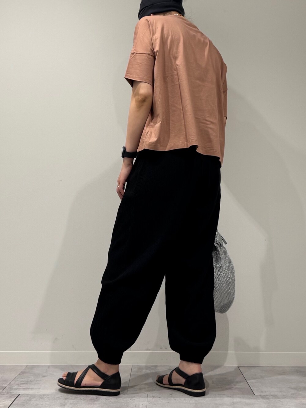 シルバー系のかごバッグ、ブラック系のサンダル、ゴールド系のネックレスを着用したレディースの春コーディネートの5枚目の写真