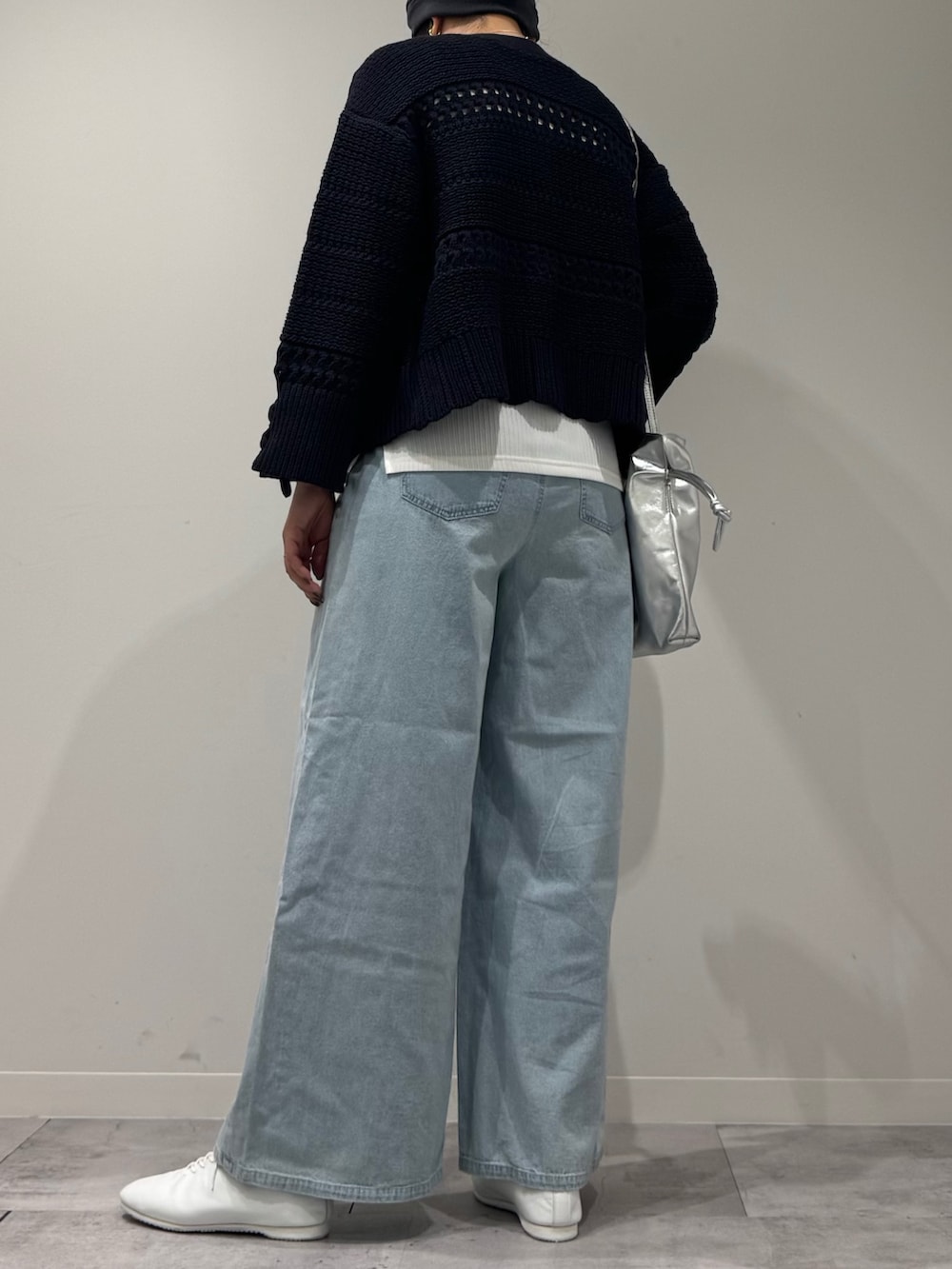 シルバー系のショルダーバッグ、ブルー系のデニムパンツ、ホワイト系のタンクトップを着用したレディースの春コーディネートの4枚目の写真