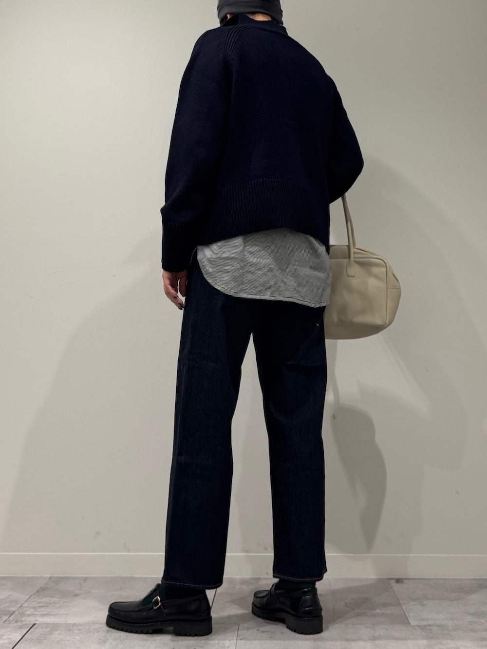 ベージュ系のボストンバッグ、ブルー系のデニムパンツ、ブラック系のローファーを着用したレディースの冬コーディネートの4枚目の写真