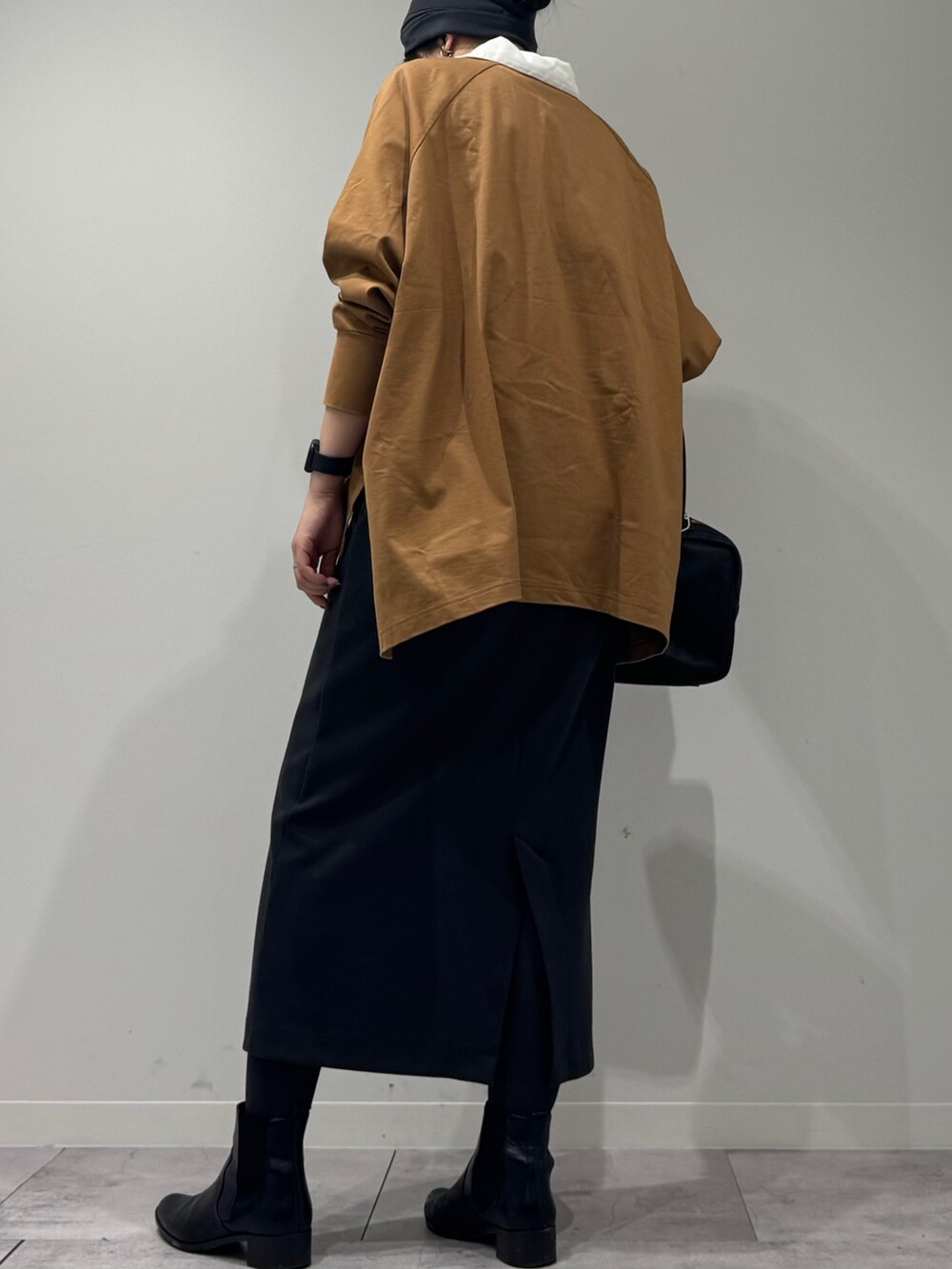 ブラック系のボストンバッグ、ベージュ系のTシャツ/カットソー、シルバー系のネックレスを着用したレディースの冬コーディネートの5枚目の写真