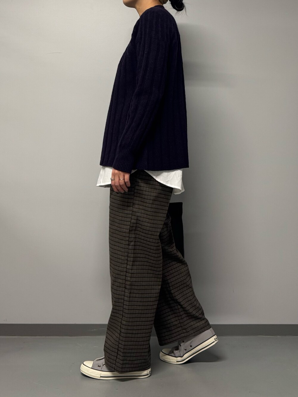 ブルー系のニット/セーター、ブラック系のトートバッグ、ブラウン系のその他パンツを着用したレディースの冬コーディネートの7枚目の写真