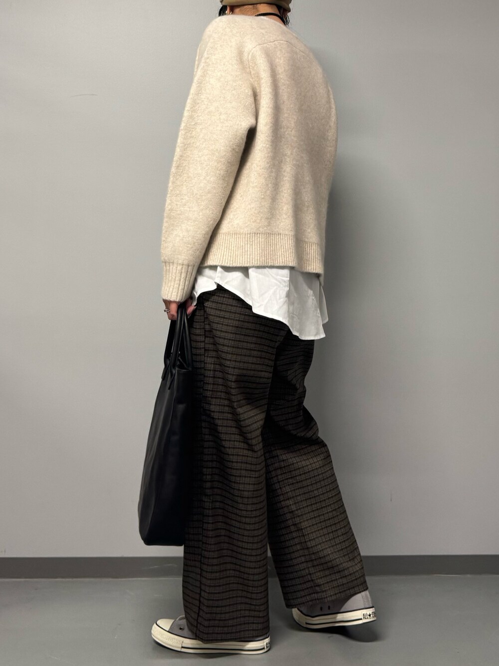 ベージュ系のニット/セーター、ブラウン系のその他パンツ、ブラック系のトートバッグを着用したレディースの冬コーディネートの6枚目の写真