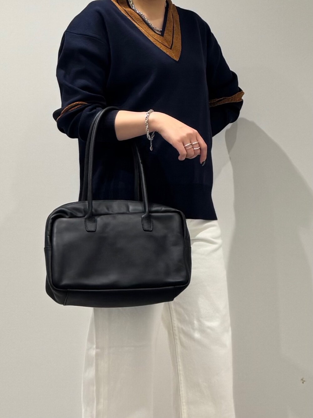 ブラック系のボストンバッグ、ホワイト系のデニムパンツ、ブラック系のローファーを着用したレディースの冬コーディネートの9枚目の写真