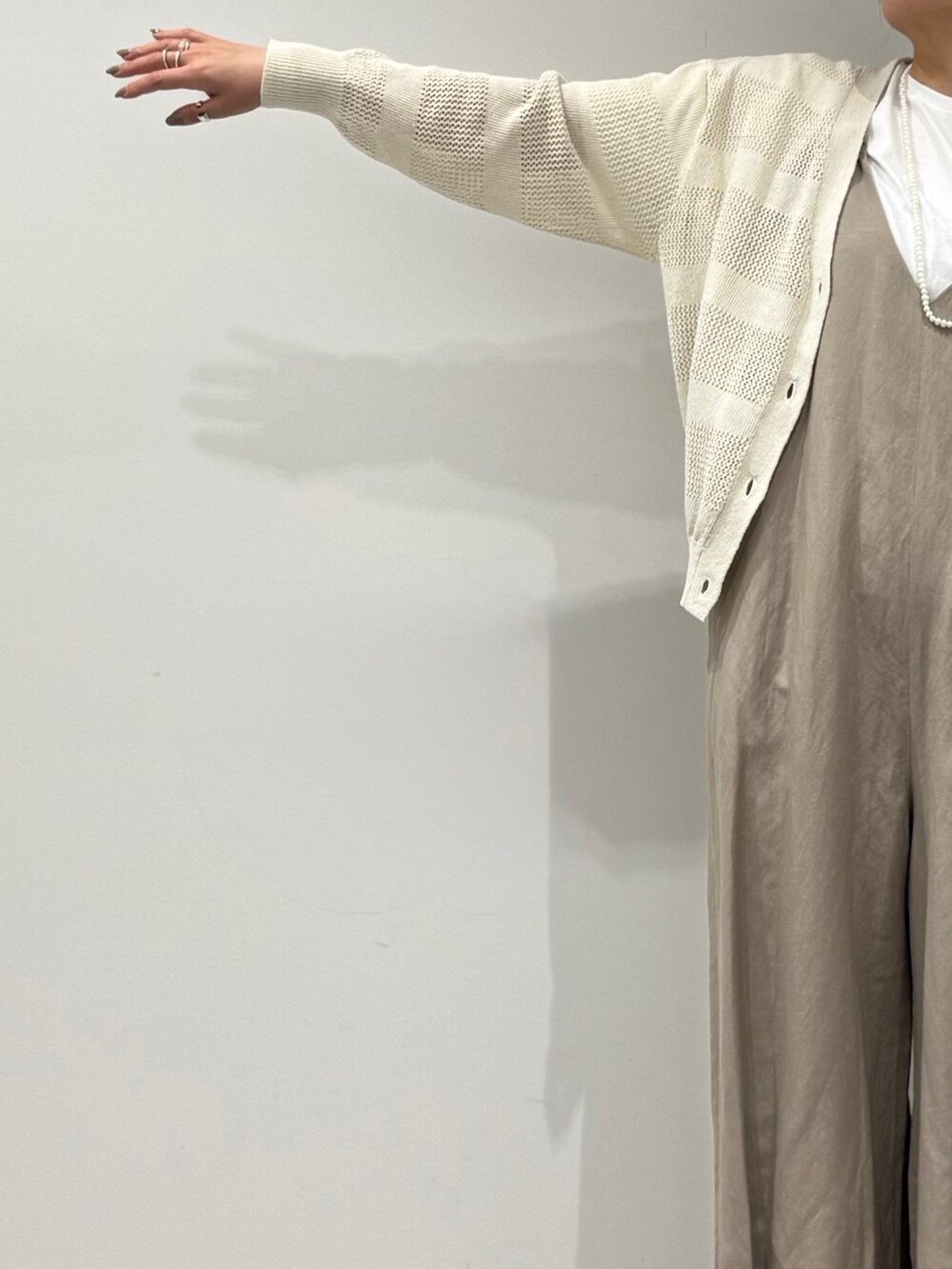 ベージュ系のサロペット/オーバーオール、ホワイト系のカーディガン/ボレロ、ベージュ系のかごバッグを着用したレディースの春コーディネートの8枚目の写真