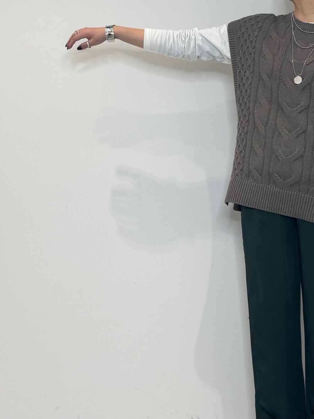 グリーン系のその他パンツ、ベージュ系のニット/セーター、ホワイト系のTシャツ/カットソーを着用したレディースの冬コーディネートの6枚目の写真