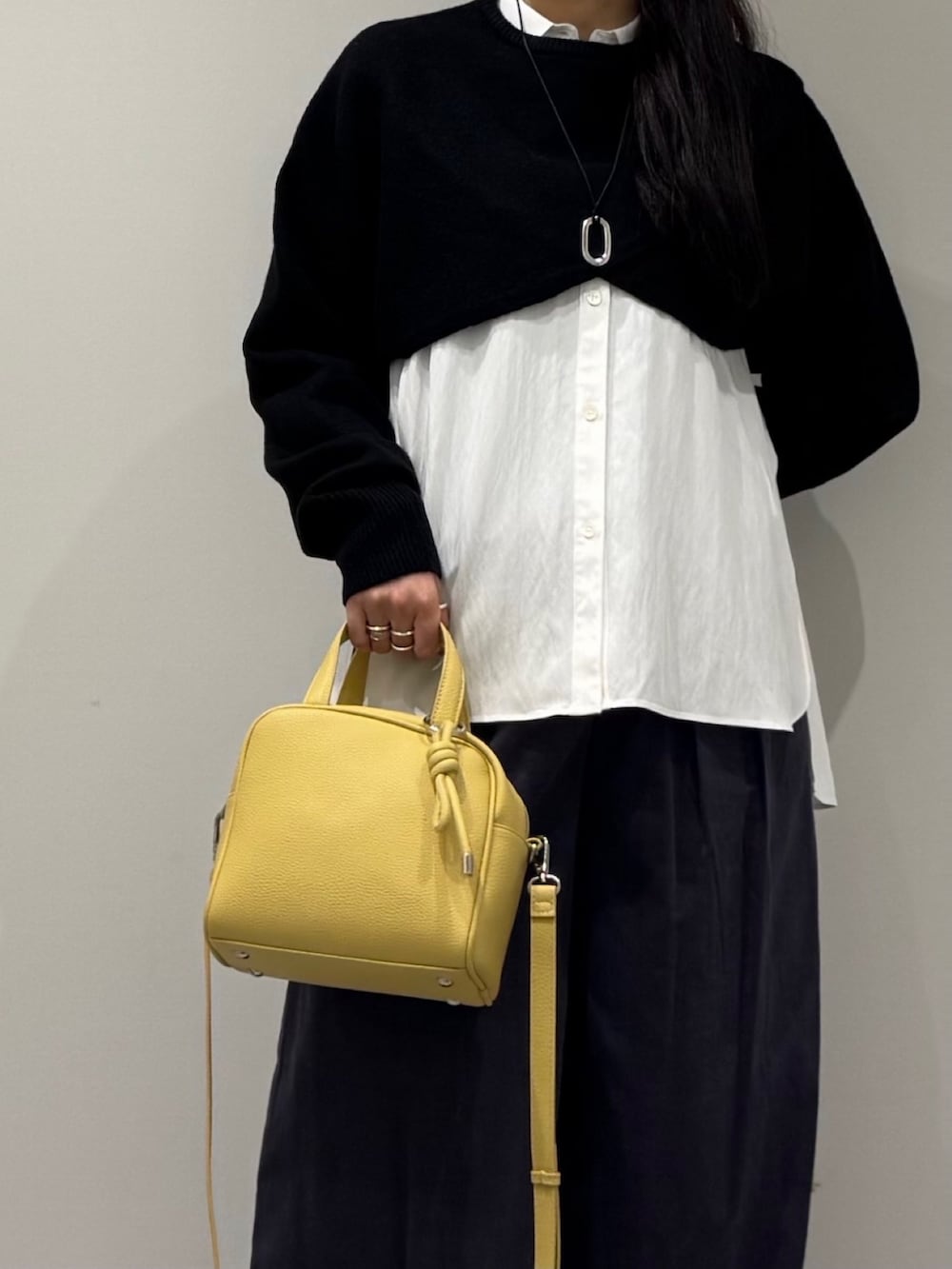 イエロー系のボストンバッグ、ブラック系のローファー、ホワイト系のシャツ/ブラウスを着用したレディースの冬コーディネートの7枚目の写真