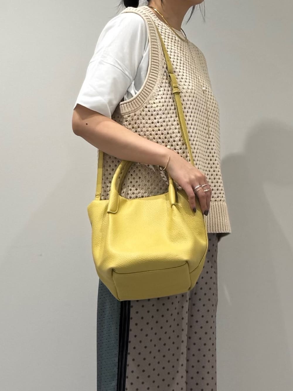 イエロー系のショルダーバッグ、ベージュ系のその他パンツ、ブラック系のローファーを着用したレディースの春コーディネートの8枚目の写真