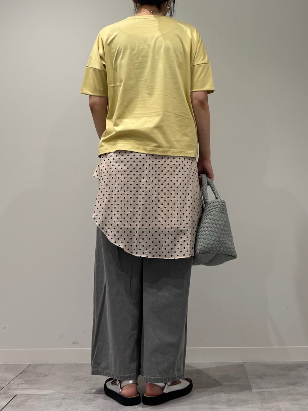 グレー系のトートバッグ、グレー系のデニムパンツ、ホワイト系のシャツ/ブラウスを着用したレディースの春コーディネートの3枚目の写真