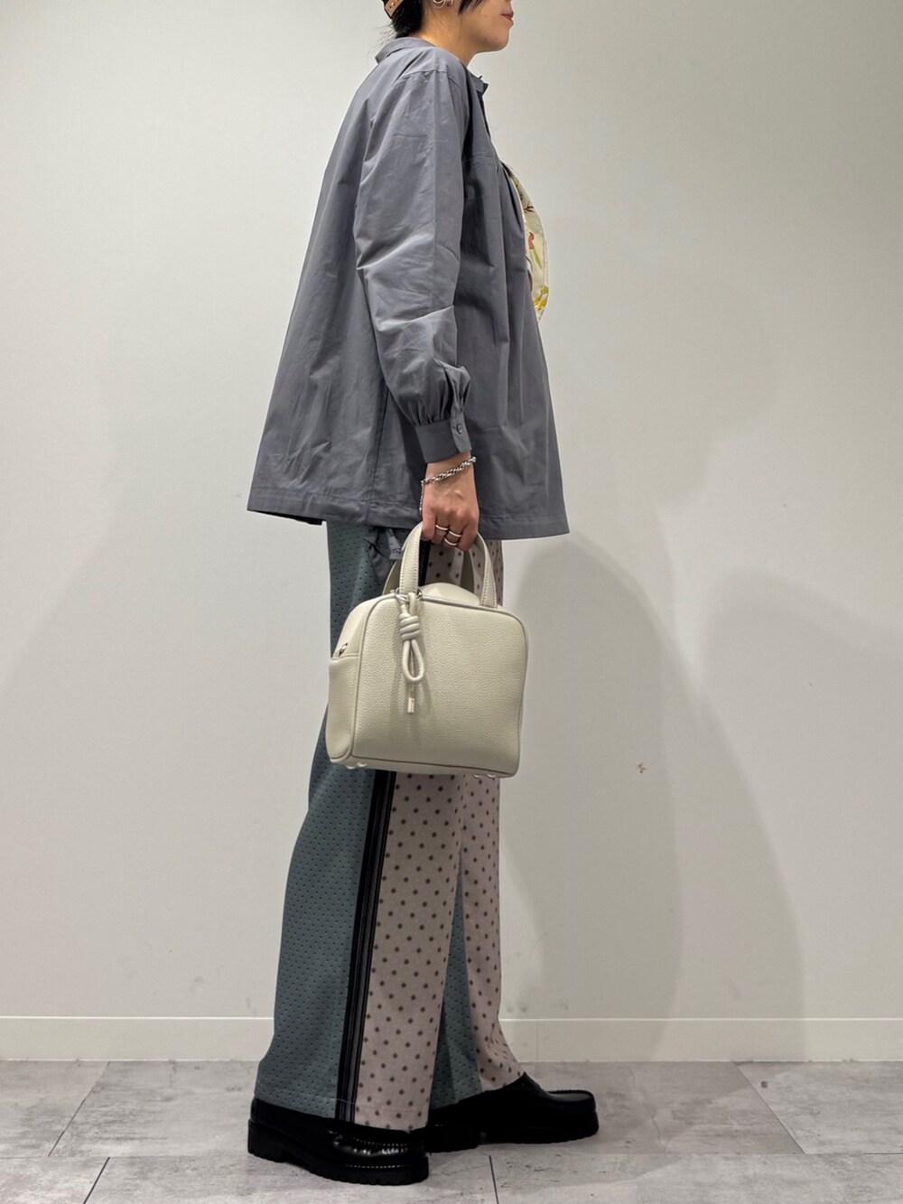 グレー系のボストンバッグ、ベージュ系のその他パンツ、ブラック系のローファーを着用したレディースの秋コーディネートの2枚目の写真