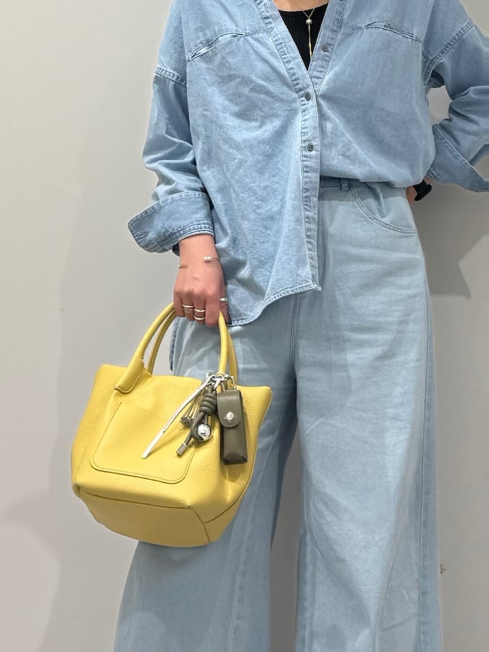 イエロー系のショルダーバッグ、ブルー系のデニムパンツ、ブラック系のローファーを着用したレディースの春コーディネートの9枚目の写真