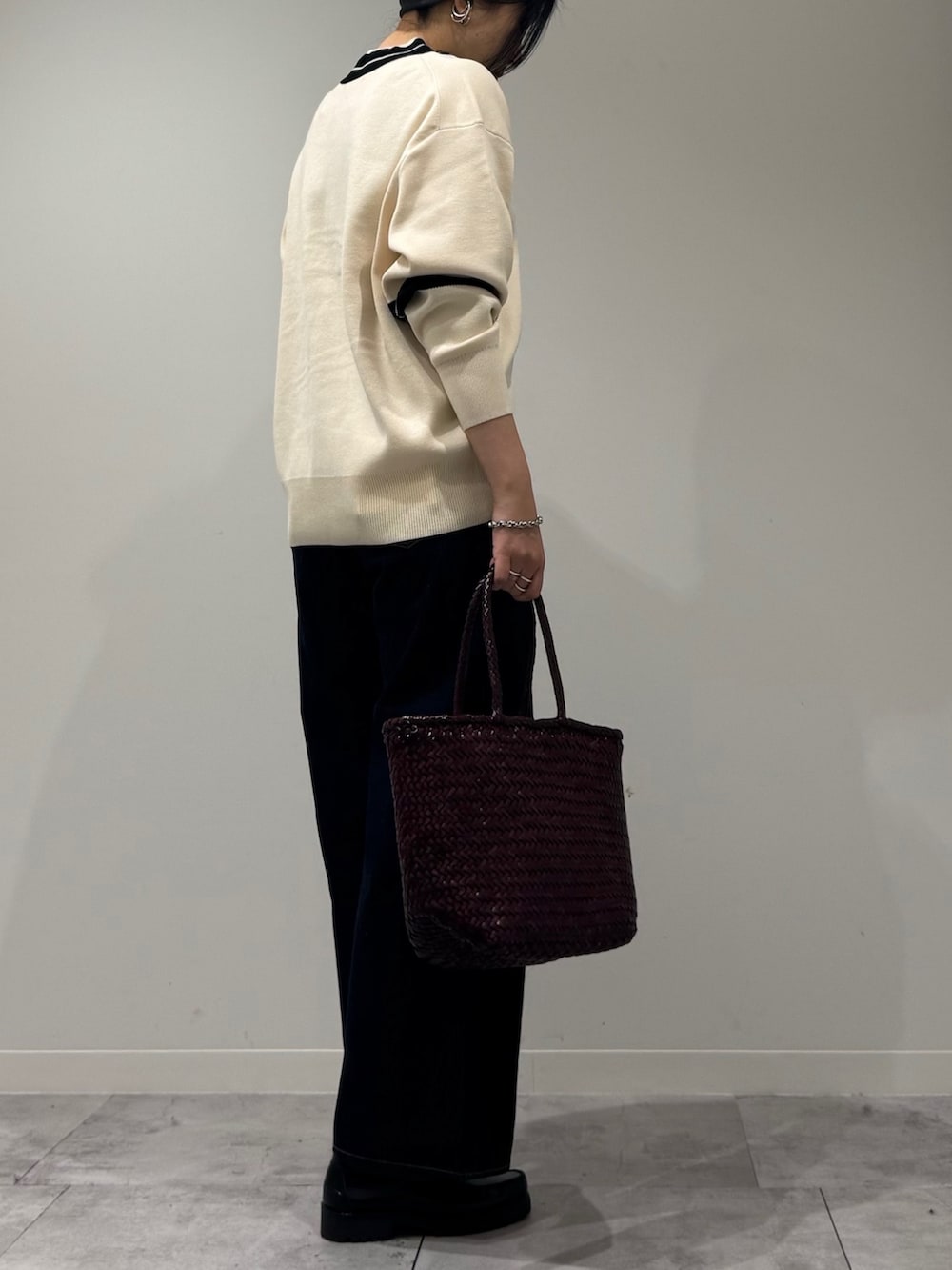 パープル系のトートバッグ、ブルー系のデニムパンツ、ブラック系のローファーを着用したレディースの冬コーディネートの3枚目の写真