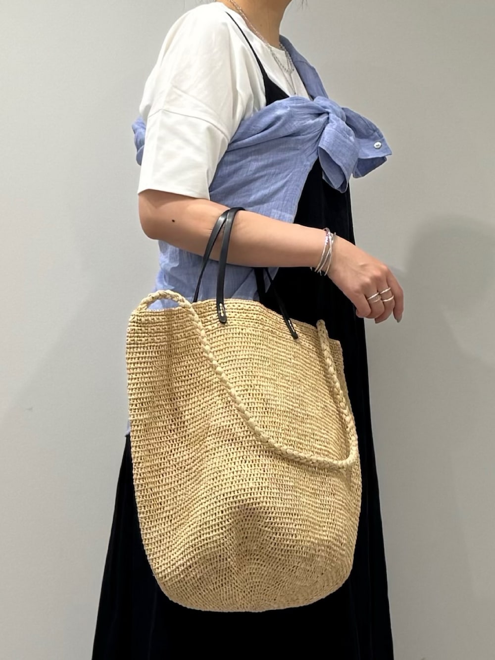 ベージュ系のかごバッグ、ブラック系のワンピース、ブラック系のサンダルを着用したレディースの夏コーディネートの8枚目の写真