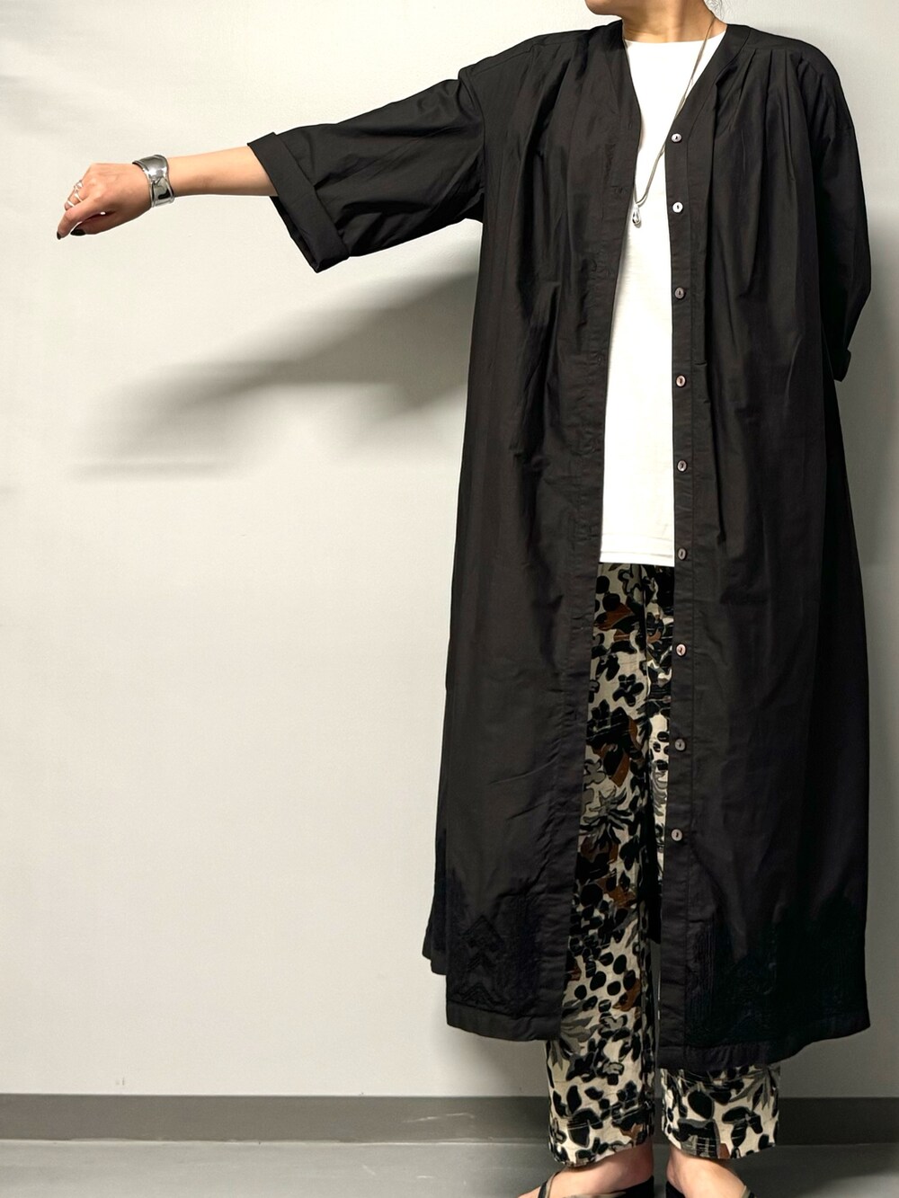 ブラック系のワンピース、ブラック系のサンダル、ホワイト系のTシャツ/カットソーを着用したレディースの夏コーディネートの5枚目の写真