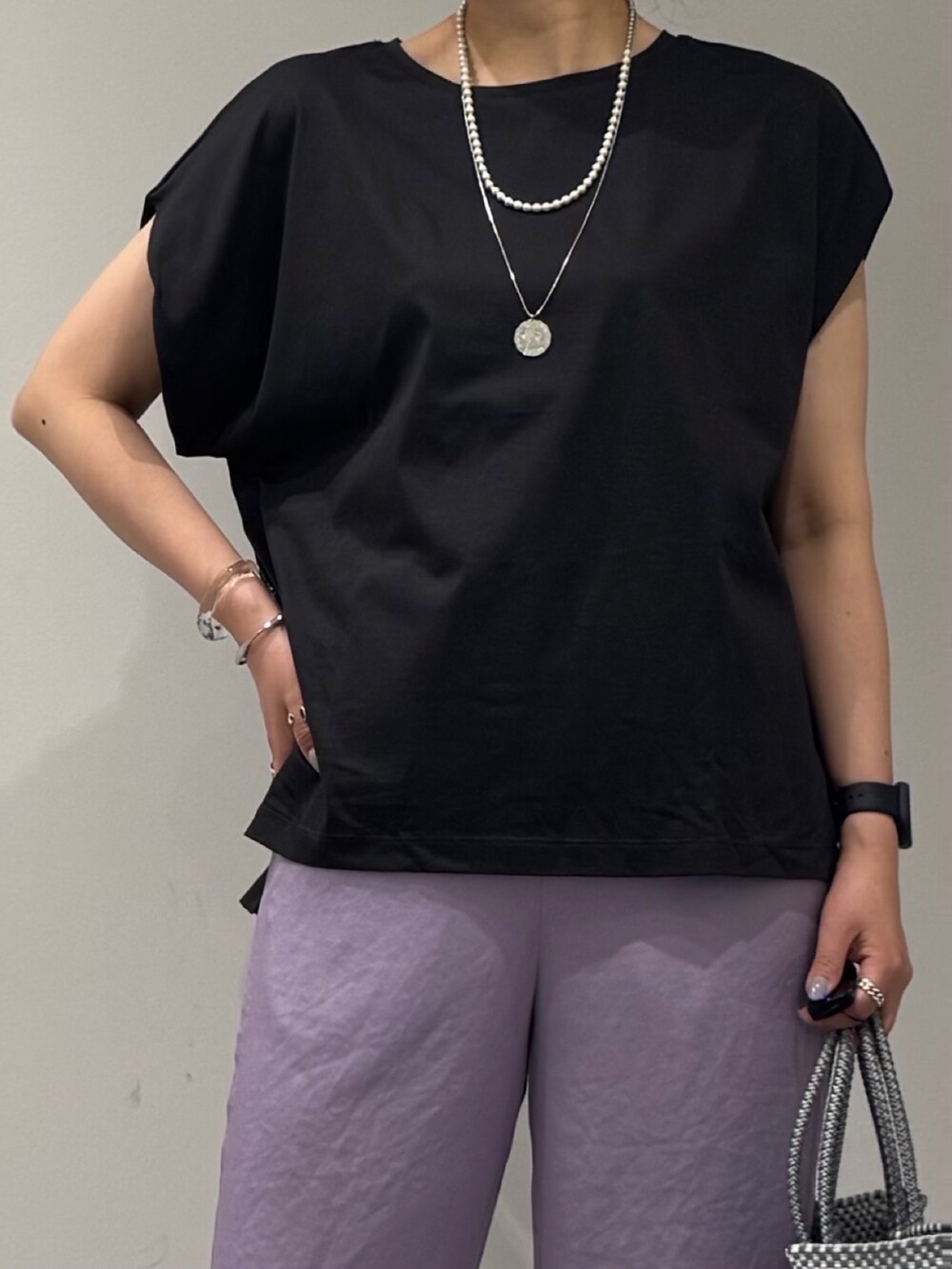 グレー系のTシャツ/カットソー、シルバー系のかごバッグ、ブラック系のサンダルを着用したレディースの夏コーディネートの6枚目の写真