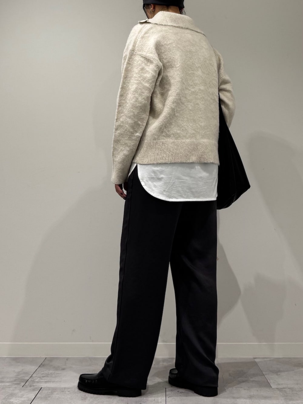 ブラック系のトートバッグ、ホワイト系のニット/セーター、ホワイト系のTシャツ/カットソーを着用したレディースの冬コーディネートの4枚目の写真