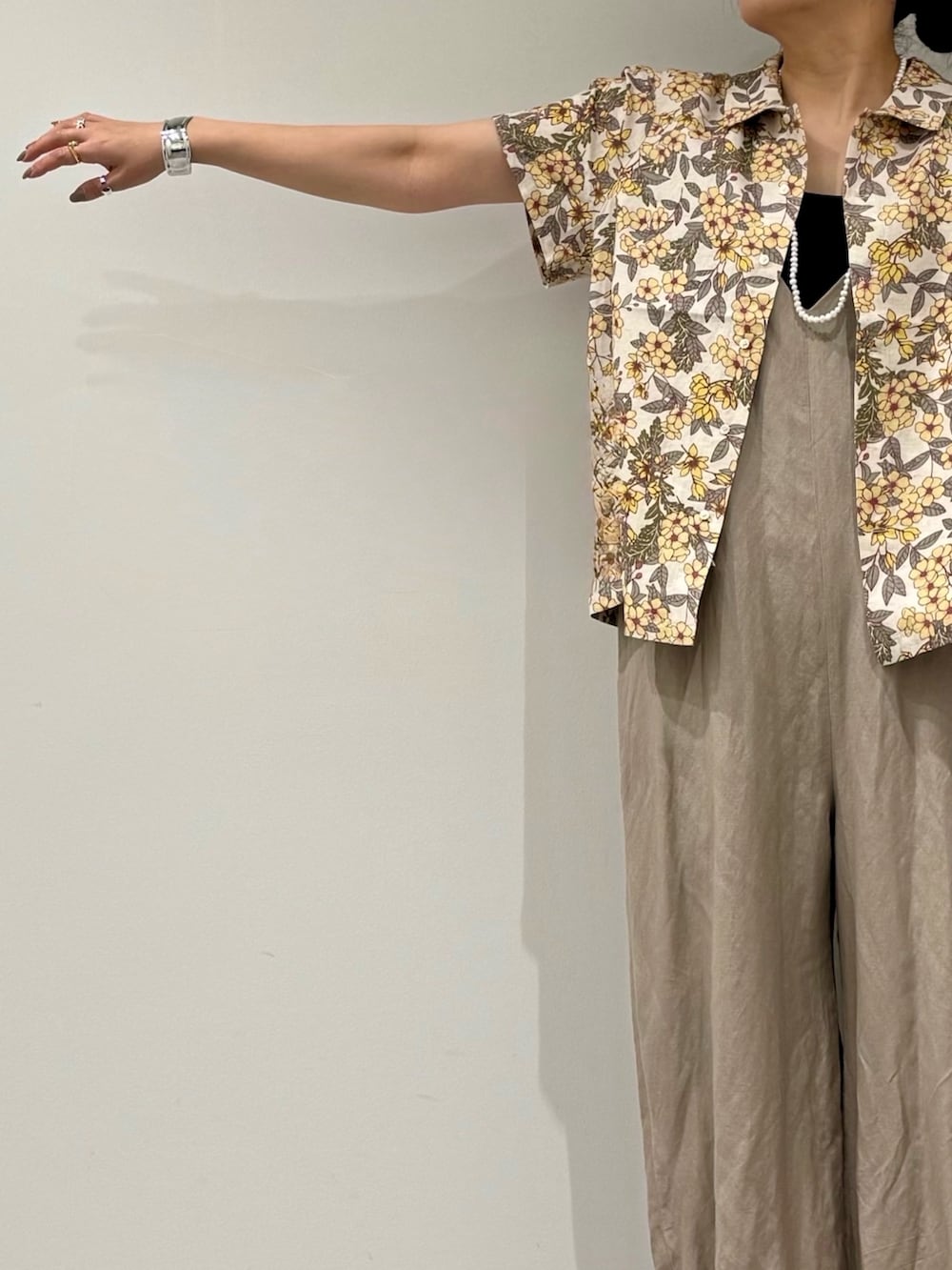 ブラウン系のトートバッグ、ベージュ系のサロペット/オーバーオール、ブラック系のサンダルを着用したレディースの春コーディネートの7枚目の写真