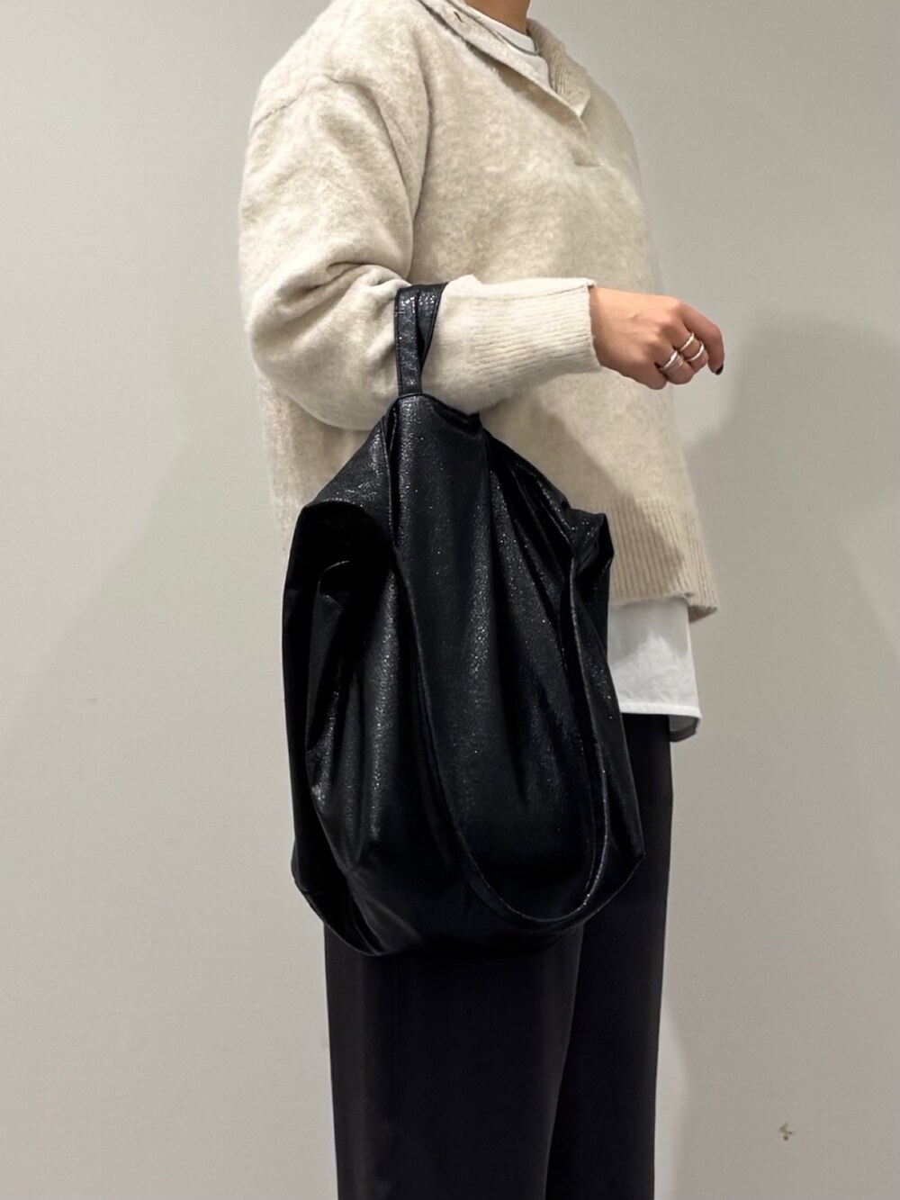 ブラック系のトートバッグ、ホワイト系のニット/セーター、ホワイト系のTシャツ/カットソーを着用したレディースの冬コーディネートの8枚目の写真