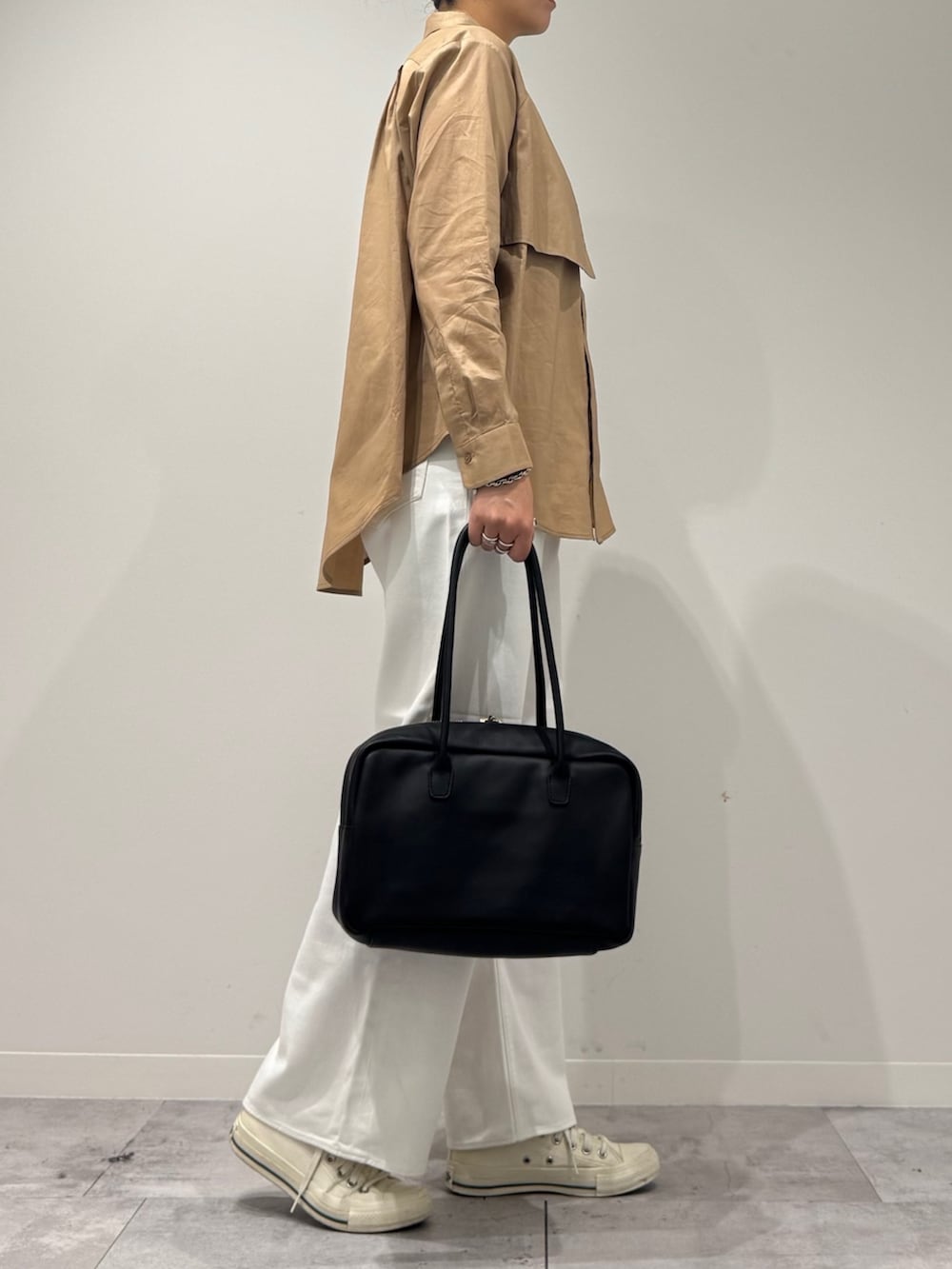 ベージュ系のシャツ/ブラウス、ホワイト系のデニムパンツ、ブラック系のボストンバッグを着用したレディースの秋コーディネートの2枚目の写真