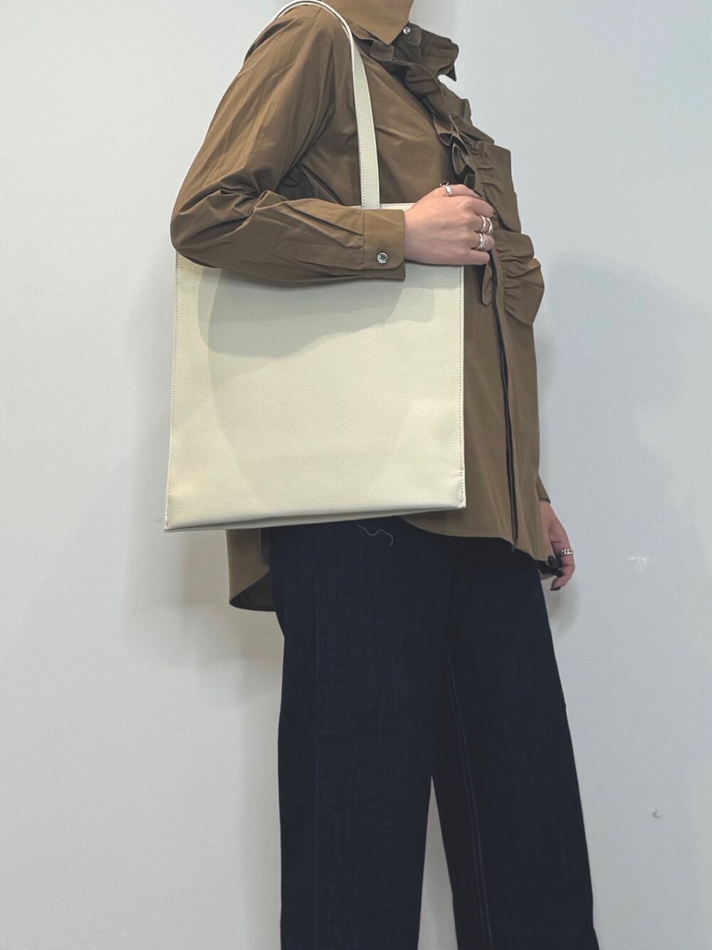 ホワイト系のトートバッグ、ブルー系のデニムパンツ、ブラウン系のシャツ/ブラウスを着用したレディースの春コーディネートの9枚目の写真