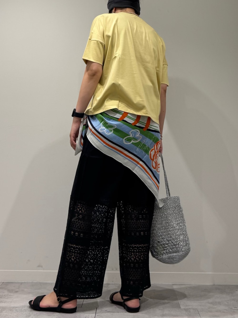 シルバー系のかごバッグ、ブラック系のその他パンツ、ブラック系のサンダルを着用したレディースの夏コーディネートの3枚目の写真