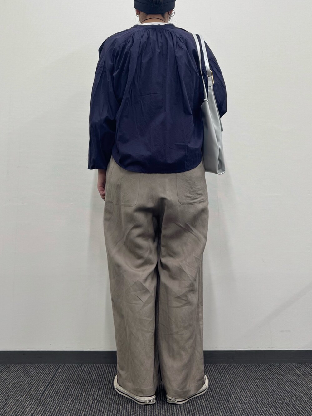 シルバー系のトートバッグ、ベージュ系のサロペット/オーバーオール、ホワイト系のTシャツ/カットソーを着用したレディースの春コーディネートの6枚目の写真