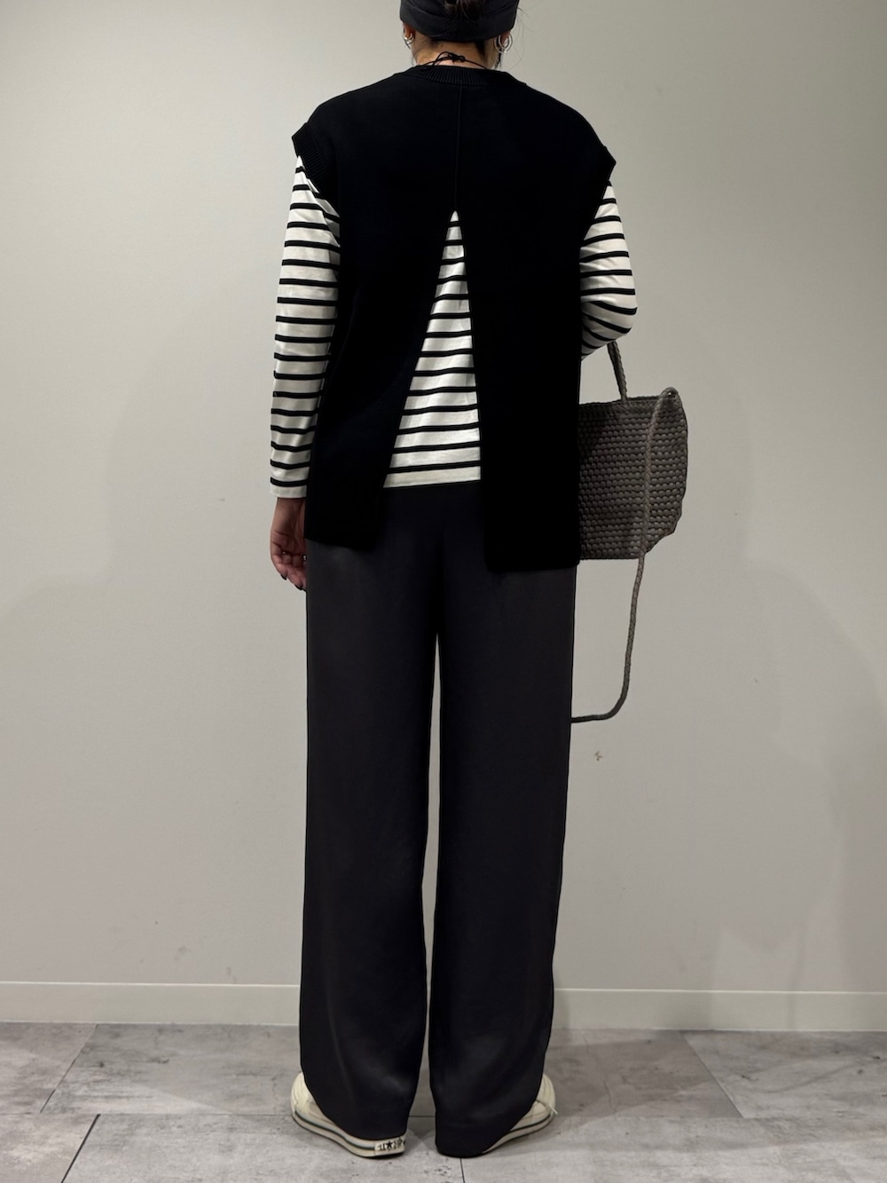 ベージュ系のトートバッグ、ブラック系のその他パンツ、ブラック系のTシャツ/カットソーを着用したレディースの秋コーディネートの3枚目の写真