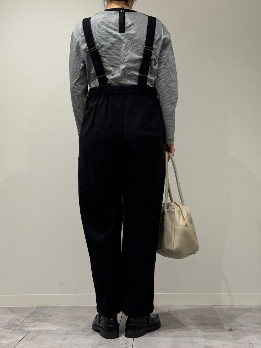 ベージュ系のボストンバッグ、ブラック系のサロペット/オーバーオール、ブラック系のローファーを着用したレディースの春コーディネートの4枚目の写真