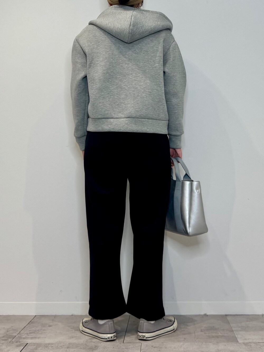 シルバー系のトートバッグ、ブラック系のサロペット/オーバーオール、グレー系のパーカーを着用したレディースの冬コーディネートの3枚目の写真