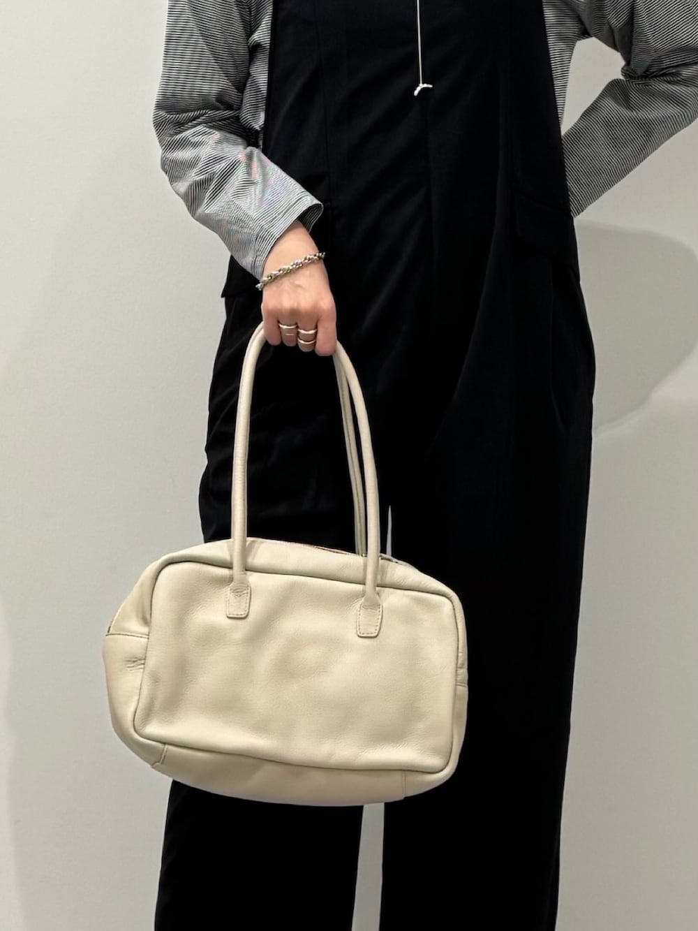 ベージュ系のボストンバッグ、ブラック系のサロペット/オーバーオール、ブラック系のローファーを着用したレディースの春コーディネートの8枚目の写真