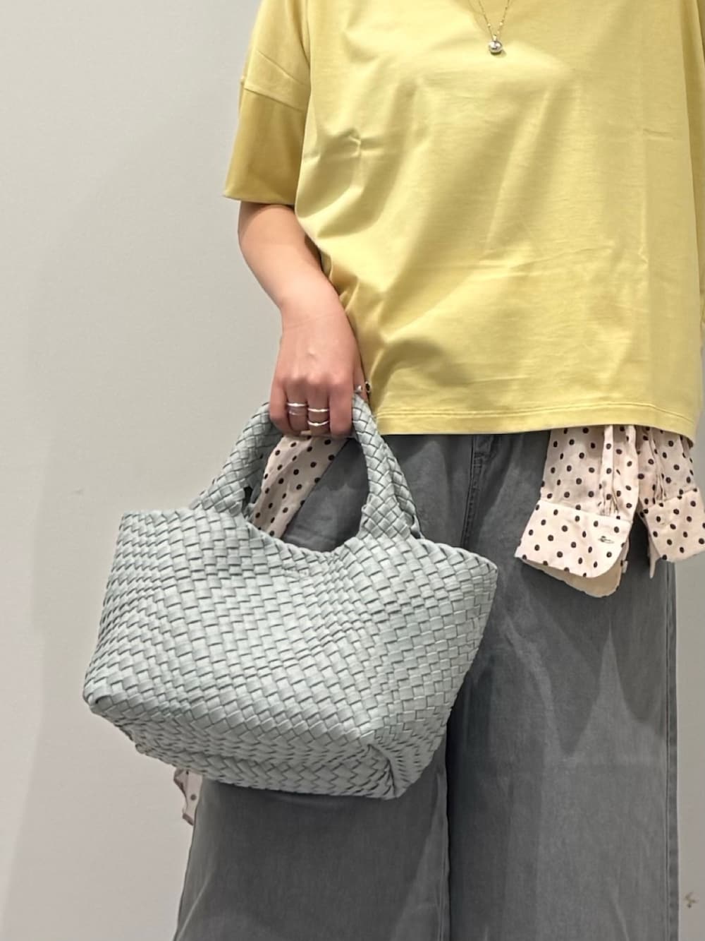 グレー系のトートバッグ、グレー系のデニムパンツ、ホワイト系のシャツ/ブラウスを着用したレディースの春コーディネートの7枚目の写真