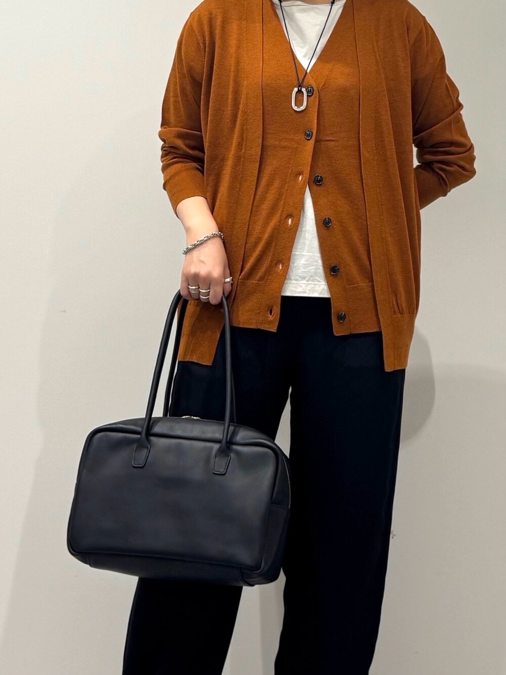 ブラック系のその他パンツ、ブラウン系のカーディガン/ボレロ、グレー系のTシャツ/カットソーを着用したレディースの秋コーディネートの9枚目の写真