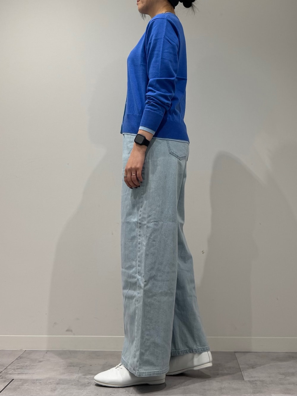 シルバー系のショルダーバッグ、ブルー系のカーディガン/ボレロ、ブルー系のデニムパンツを着用したレディースの冬コーディネートの5枚目の写真